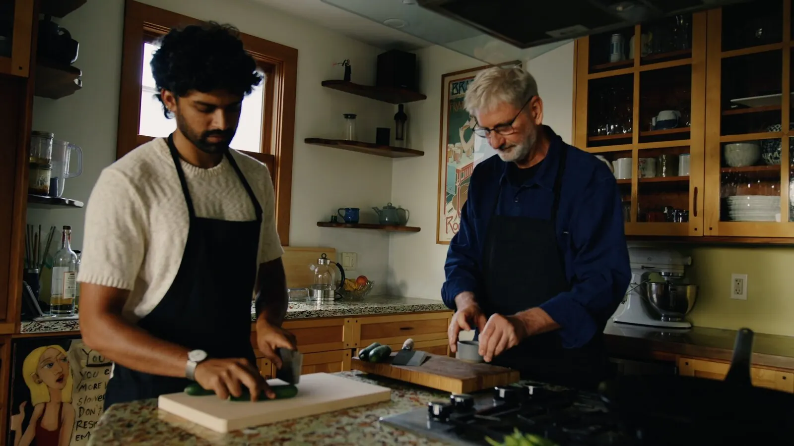 Akshay Prabhu and a home cook chop cucumber side by side at a kitchen counter